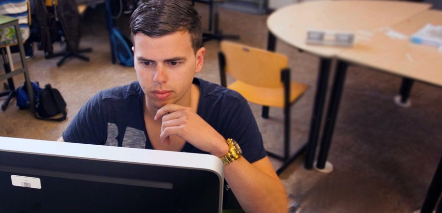 Student met gouden horloge kijkt op Apple scherm